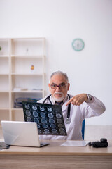 Old male doctor radiologist working at the hospital