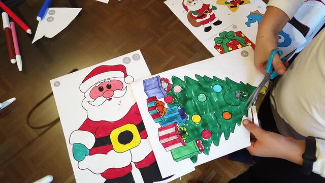 Boy child 7 years old draws  Santa Claus and the tree - preparation and decorations for Christmas 2021 - year of epidemic due to Covid-19 Coronavirus lockdown