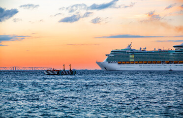 Luxury cruise ship arriving port at sunset
