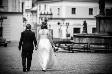 groom and bride walking on the square