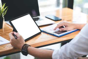 hand image of a male freelancer holding a blank screen tablet in his modern workplace