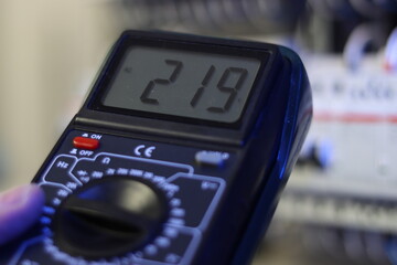 Measurement of voltage at electrical terminals using a multimeter.