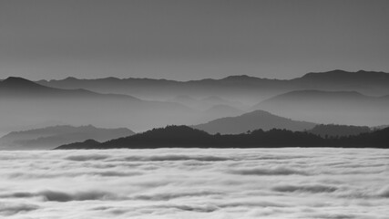 hilly mountain landscape with fog at dawn