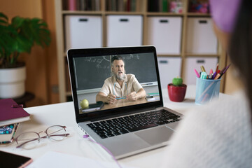 Unrecognizable Student learning watching online video class with Math Professor from home