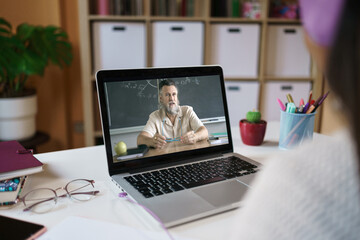Unrecognizable Student learning watching online video class with Math Professor from home