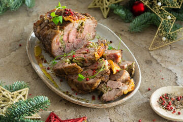 Baked chopped pork stuffed with spiced vegetables and sprouts. Holiday roaster meat with red pepper on a plate. Christmas dinner.
