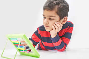 Schoolboy do mental math. Mental mathematics. 8 years old multiracial boy busy with mental...