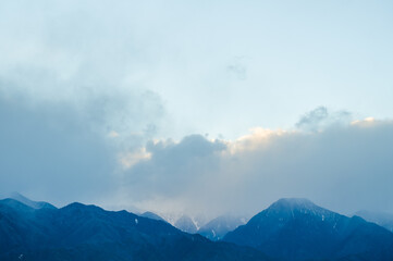 夕暮れ時に雲がかかった北アルプス