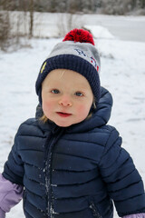 Fototapeta na wymiar happy small child infant playing in snowy winter day