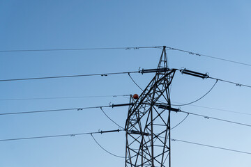 High voltage electrical tower against the blue sky.
