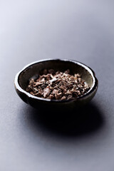 Dry root of Rhodiola rosea. Golden root, rose root. Healthy medical plant on dark paper background. Close up. Copy space.	