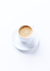 Fototapeta premium Cup of coffee on bright paper background. Copy space.
