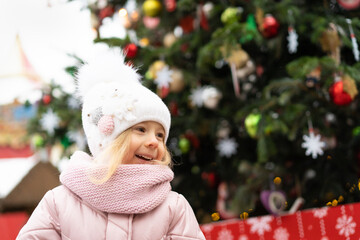 winter portrait of a happy little girl near the Christmas tree