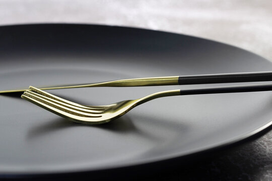 Fancy Gold Fork And Knife On Black Plate.