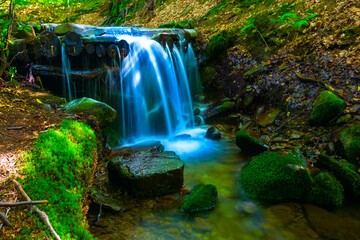 small waterfall on mountain river, beautiful outdoor natural background