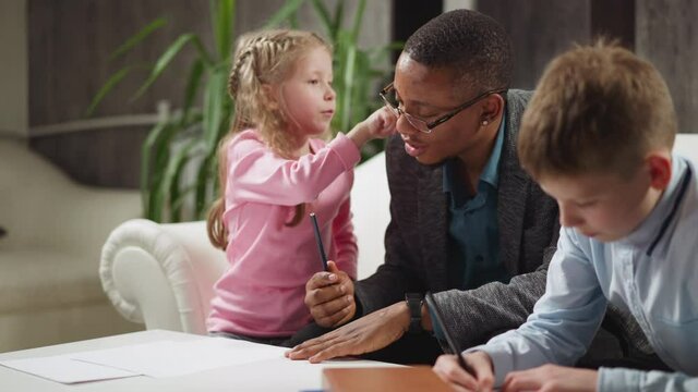 Girl pupil touches black man ear learning body parts names