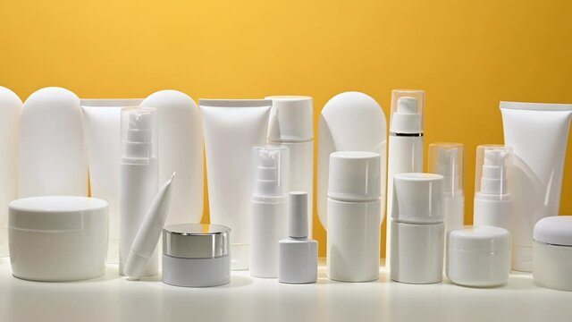 jar, bottle and empty white plastic tubes for cosmetics on a yellow background. Packaging for cream, gel, serum, advertising and product promotion, mock up