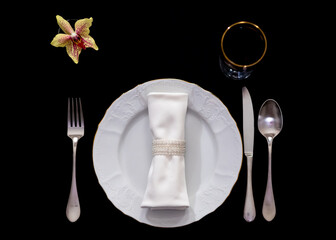 White dishes on a black background. Table setting.