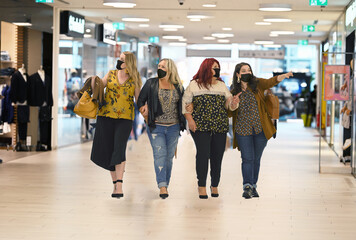 Plus size women with green passport and fashion clothes at the shop center walking with protective...