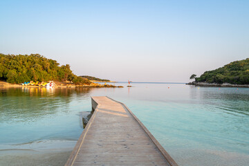 Long boardwalk from the white sandy beach into the turquoise sea water