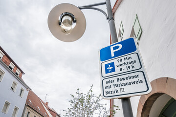 Straßenschilder mit Straßenlampe in Deutschland mit dem Hinweis Parken 90 Minuten Werktags 8 -19...