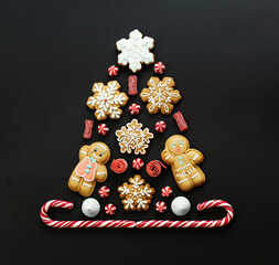 Flat lay composition with Christmas tree made of cookies on black background