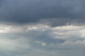 Fototapeta premium Dark heavy clouds in the blue sky, dramatic sky with dark storm clouds