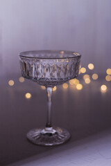 glass of champagne on gray background with christmas lights
