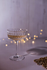 glass of champagne on white background and christmas lights
