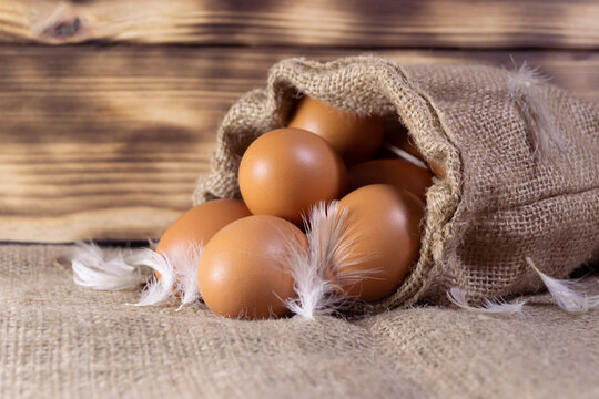 Fresh brown chicken eggs in a sacking on wooden background. Easter holidays concept