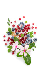 Composition from multi-colored berries and leaves on a white background.