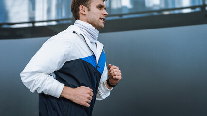 Adult sportsman training outdoors, running in the city
