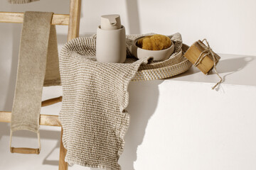 Organic handmade soap on waffle linen towels, sea sponge and beige soap dispenser. Bathroom zero waste accessories. Daily body care, spa and wellness zero waste bathroom concept