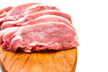 chopped into pieces raw pork on a wooden cutting board on a white background.