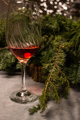 transparent glass with red wine, pine branch on the Christmas table. close up. on a light table