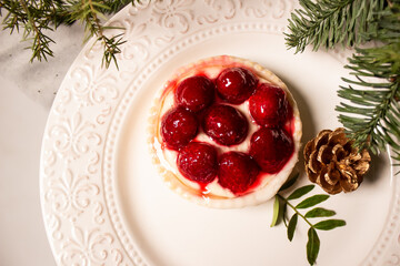 bright cake on a white plate with a pine cone