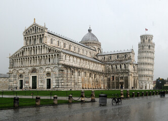 Cathedral And Leaning Tower At Piazza Dei Miracoli In Pisa On A Spring Day With Heavy Rain