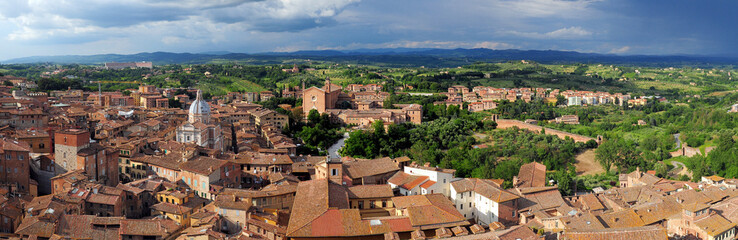 Fototapeta na wymiar View From The Tower Torre Del Mangia To The Old Town Of Siena Tuscany Italy On A Beautiful Spring Day With A Blue Sky And A Few Clouds