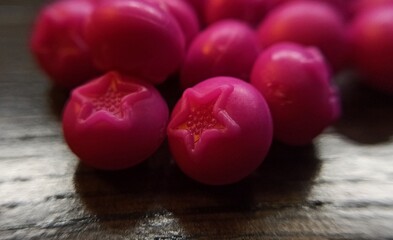 Artificial red berries close-up. Toy blueberries. Dollhouse food. Berry with a receptacle on a wooden surface. Berries for playng