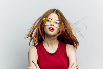 emotional woman in red dress yellow glasses posing