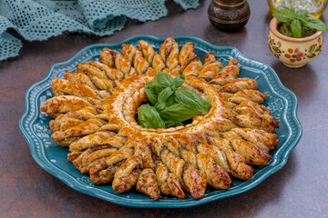 Pastry Christmas Wreaths. Puff pastry braided pull-apart bread served on a plate with a pesto dip....