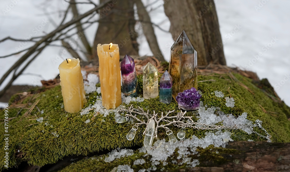 Wall mural crystal minerals, candles, witch amulet on moss in forest, natural background. Gemstones for esoteric Crystal Ritual, Witchcraft, spiritual energy practice. Wiccan tradition for winter season