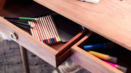 High angle view of handcrafted wooden pencils inside an oak wood desk drawer.