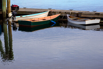 Fototapeta na wymiar three boats sitting idle at a pier in maine