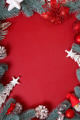 Frame made of Christmas decorations on red background with copy space