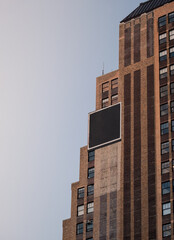 Black box sign with blank space for your logo on the wall of an old building business centre, mockup. Tall modern building with brick exterior and billboard with copy space for advertising content.