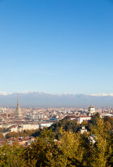 Naklejka premium Turin panorama with Alps and Mole Antonelliana, Italy. Skyline of the symbol of Piedmont Region with Monte dei Cappuccini - Cappuccini's Hill. Sunrise light.