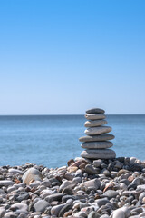 pebble pyramid on the beach. tower made of flat stones by the sea,