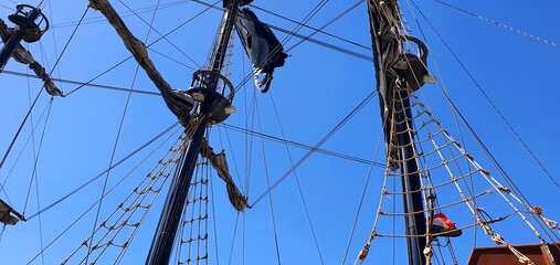 High masts on a ship with sails raised. Masts and blue sky. Sailing vessel.