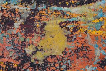 Multicolor surface. Concrete wall with old paint. Colors - burgundy, red, yellow, blue. Vintage wall concept.